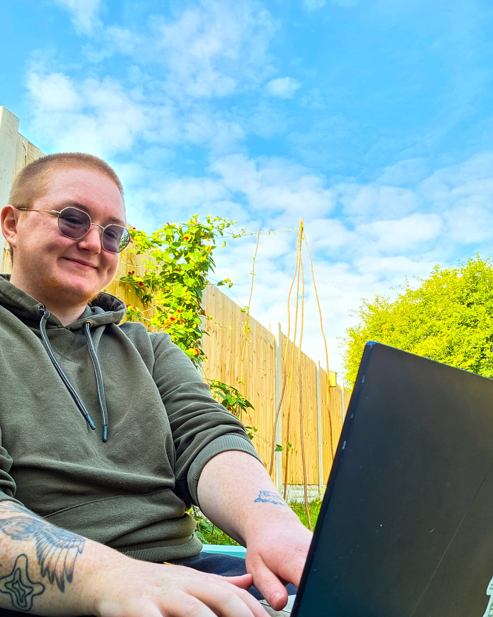 Felix working from his laptop in a garden.